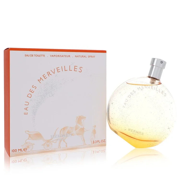 Hermès Eau des Merveilles – sparkling woody amber scent in round orange-tinted bottle with starry detail. 100ml