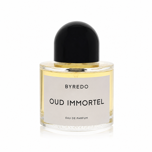 A bottle of Byredo Oud Immortel Eau de Parfum with a black dome-shaped cap, clear glass bottle showing the golden-yellow liquid, and a minimalist white label.