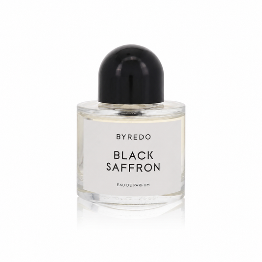 A bottle of Byredo Black Saffron Eau de Parfum with a clear glass body, white label, and a glossy black dome-shaped cap, set against a plain white background.
